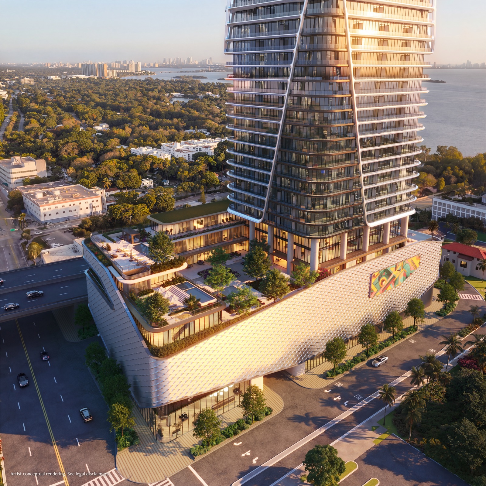 Aerial view of Anantara Residences Miami's lattice-patterned amenity podium and landscaped deck, with the residential tower rising above and Biscayne Bay and the Miami skyline on the horizon.