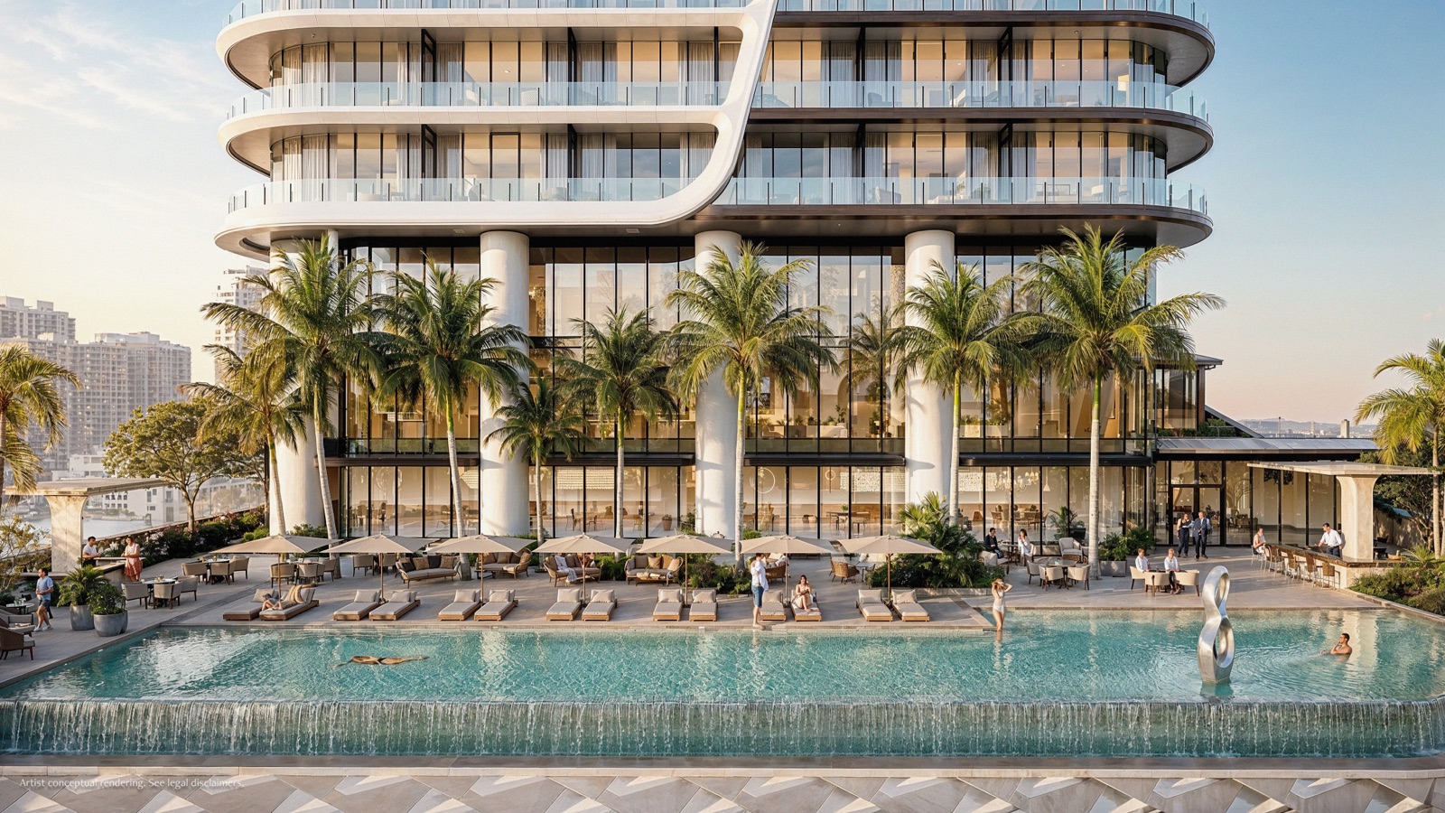 The resort pool deck at Anantara Residences Miami at golden hour — an infinity-edge pool with a cascading waterfall, palms, day beds, and the lattice-clad podium rising behind.